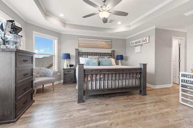 bedroom with a raised ceiling, ceiling fan, crown molding, and light hardwood / wood-style flooring