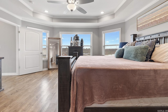 bedroom featuring ceiling fan, a tray ceiling, ornamental molding, and hardwood / wood-style floors