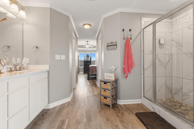 bathroom featuring vanity, crown molding, hardwood / wood-style flooring, and a shower with door