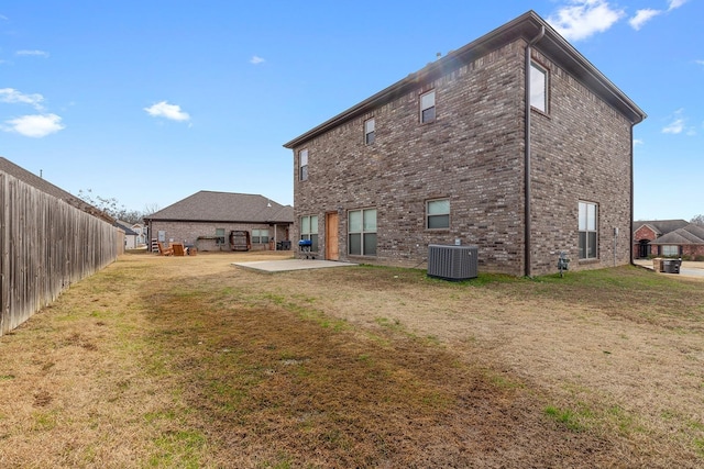 back of house with a lawn, central AC unit, and a patio