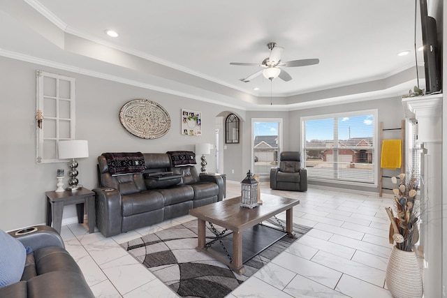 living room featuring ceiling fan, crown molding, and a raised ceiling