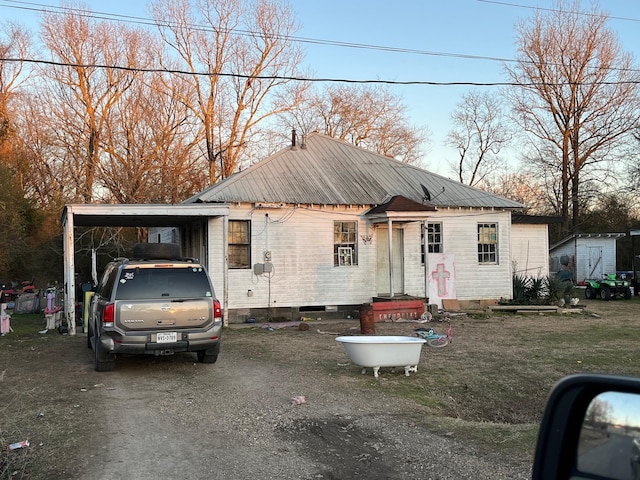 view of front of property featuring a shed and a carport