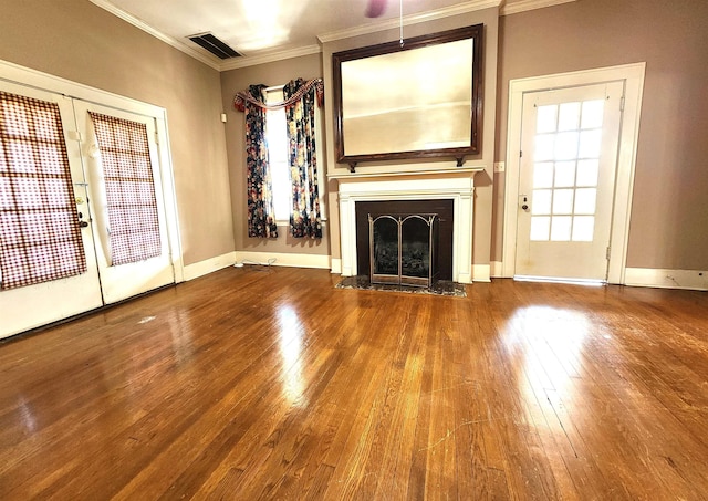 unfurnished living room featuring hardwood / wood-style flooring, crown molding, and french doors