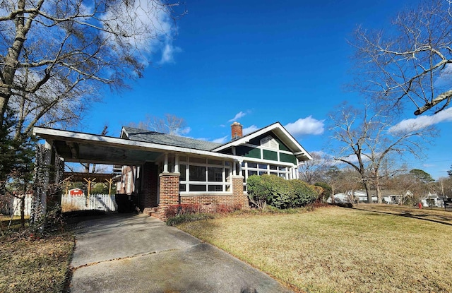 view of front of house featuring a front lawn, a sunroom, and a carport