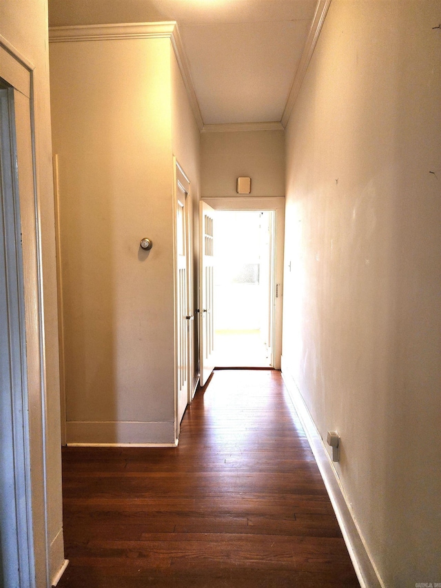 corridor with dark wood-type flooring and ornamental molding