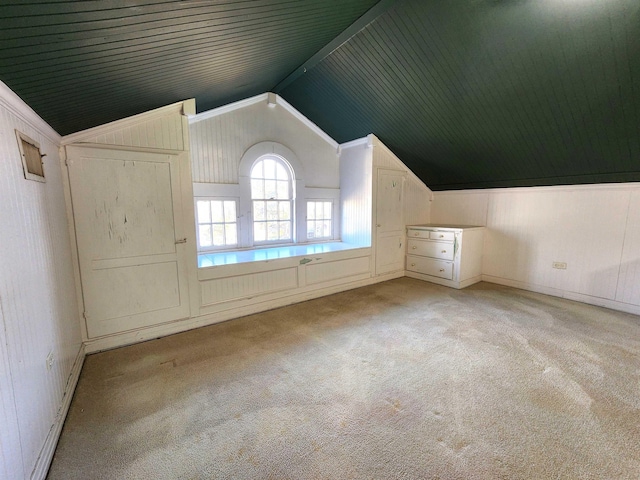 bonus room with vaulted ceiling and light carpet