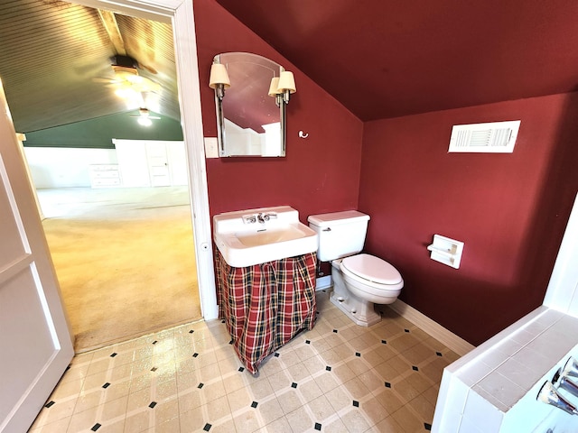 bathroom featuring toilet, lofted ceiling, and sink