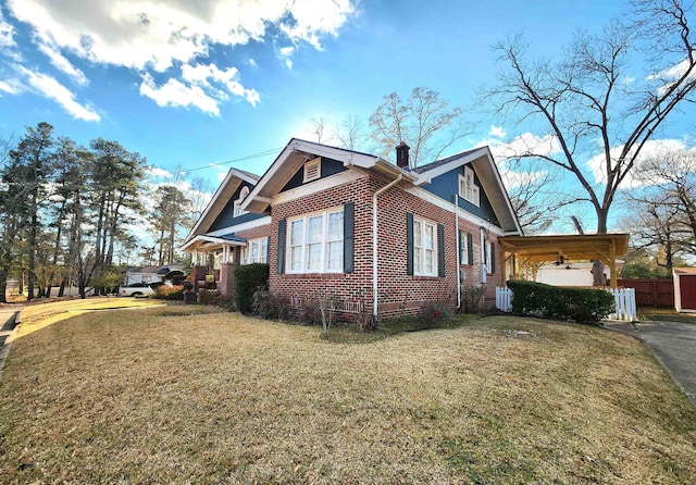 view of side of home featuring a carport and a yard