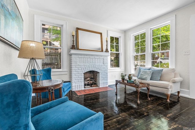 sitting room featuring a brick fireplace, dark hardwood / wood-style flooring, crown molding, and a healthy amount of sunlight