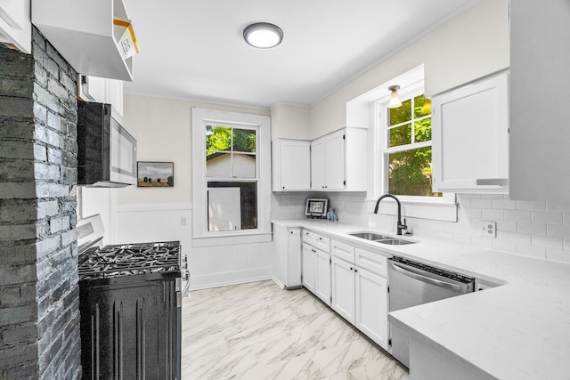 kitchen with stainless steel appliances, white cabinets, tasteful backsplash, and sink