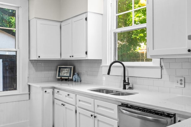 kitchen featuring decorative backsplash, dishwasher, white cabinets, and sink