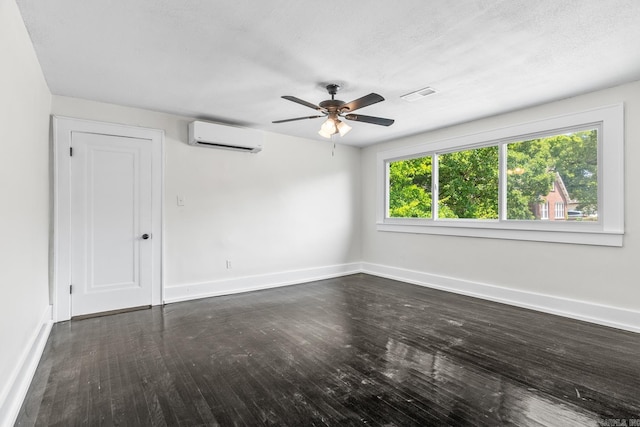 spare room featuring ceiling fan, a wall mounted AC, dark wood-type flooring, and a textured ceiling