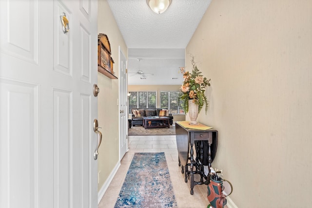 tiled foyer with ceiling fan and a textured ceiling