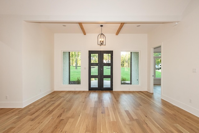 foyer entrance featuring french doors, beamed ceiling, a chandelier, and light hardwood / wood-style floors