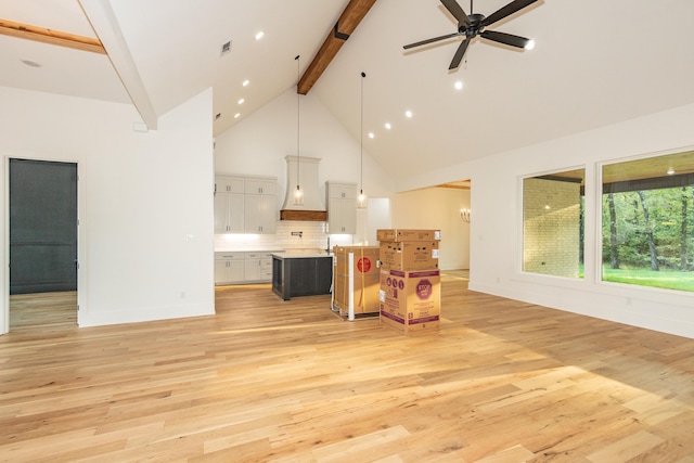 living room featuring ceiling fan, high vaulted ceiling, beamed ceiling, and light hardwood / wood-style flooring