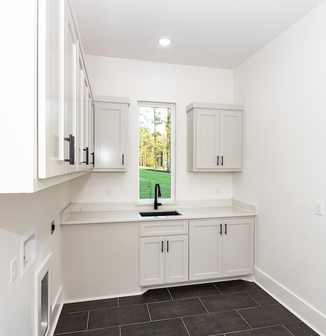 clothes washing area with washer hookup, cabinets, and sink