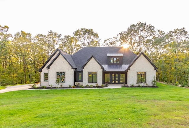 modern inspired farmhouse with a front lawn and french doors