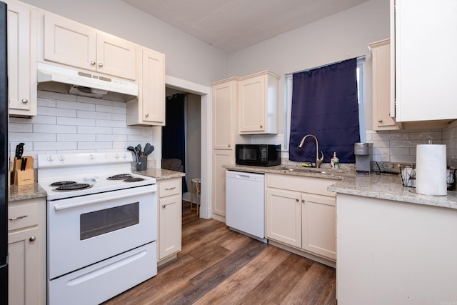 kitchen featuring light stone countertops, white appliances, dark hardwood / wood-style flooring, decorative backsplash, and sink