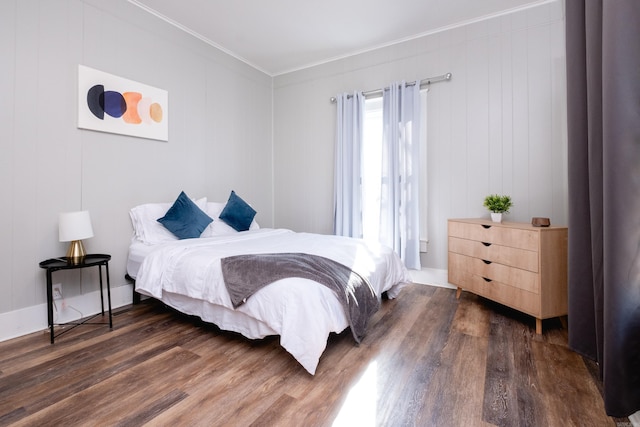 bedroom with dark hardwood / wood-style flooring and crown molding