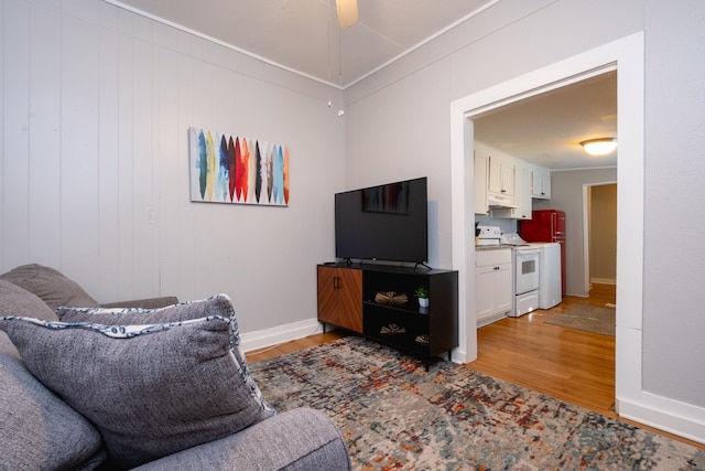 living room with ceiling fan, light hardwood / wood-style flooring, and ornamental molding