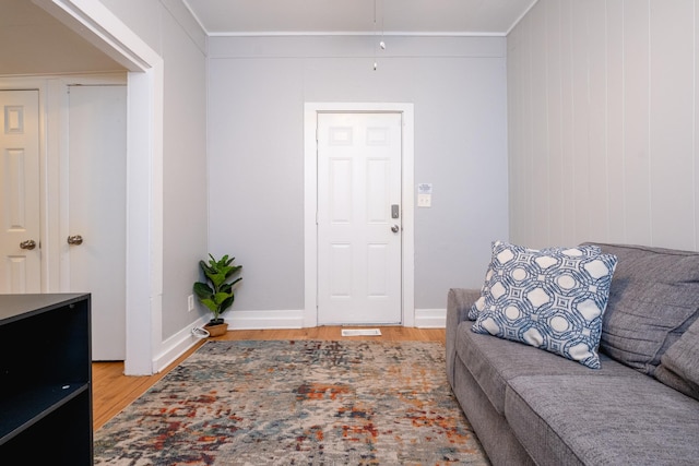 living room featuring light wood-type flooring and ornamental molding