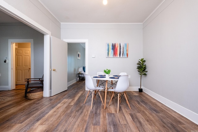 dining area featuring dark hardwood / wood-style flooring and ornamental molding