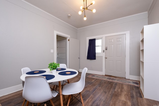 dining room featuring dark wood-type flooring, ornamental molding, and an inviting chandelier