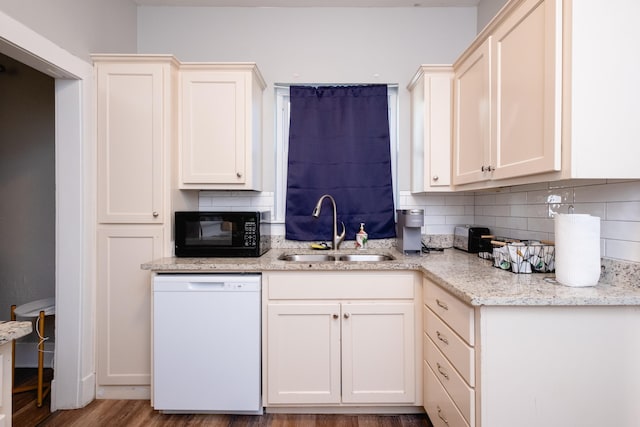 kitchen featuring tasteful backsplash, light hardwood / wood-style floors, sink, white dishwasher, and light stone counters