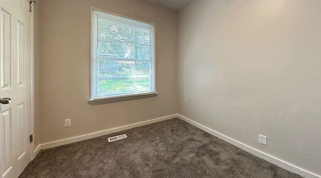 unfurnished room with dark carpet