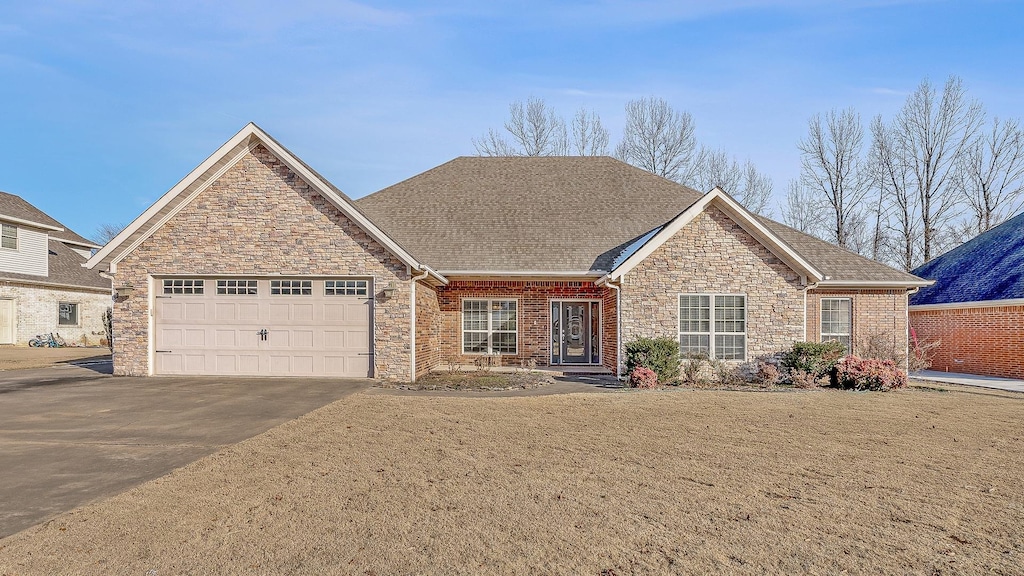 view of front of house with a garage and a front lawn