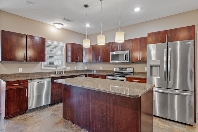 kitchen featuring hanging light fixtures, sink, a kitchen island, stainless steel appliances, and stone countertops