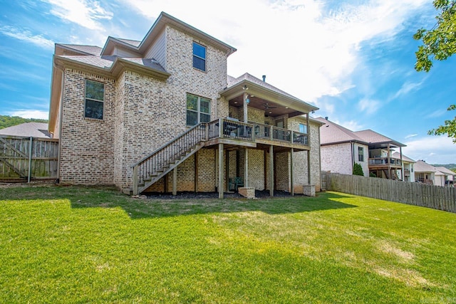 back of house featuring a lawn and a wooden deck