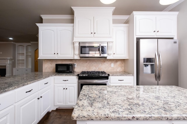 kitchen with crown molding, white cabinets, tasteful backsplash, and stainless steel appliances