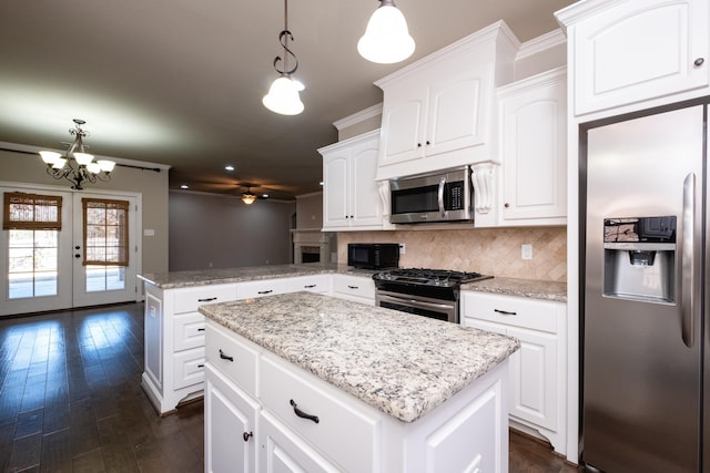 kitchen with pendant lighting, a kitchen island, white cabinetry, stainless steel appliances, and kitchen peninsula