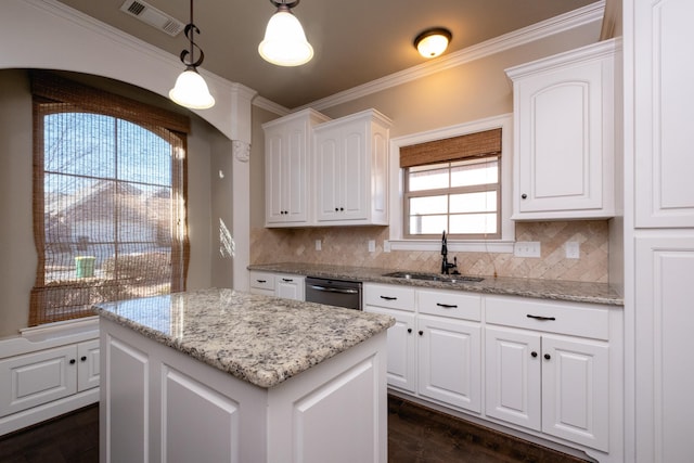 kitchen featuring decorative light fixtures, sink, backsplash, and white cabinets