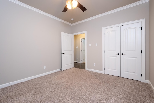 unfurnished bedroom featuring crown molding, carpet, a closet, and ceiling fan