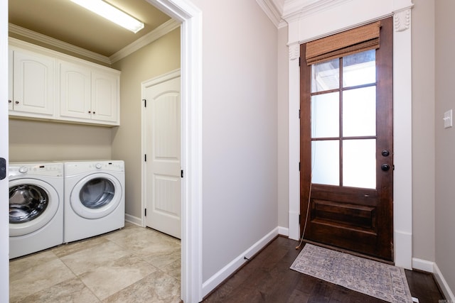 laundry area with cabinets, ornamental molding, and washing machine and clothes dryer