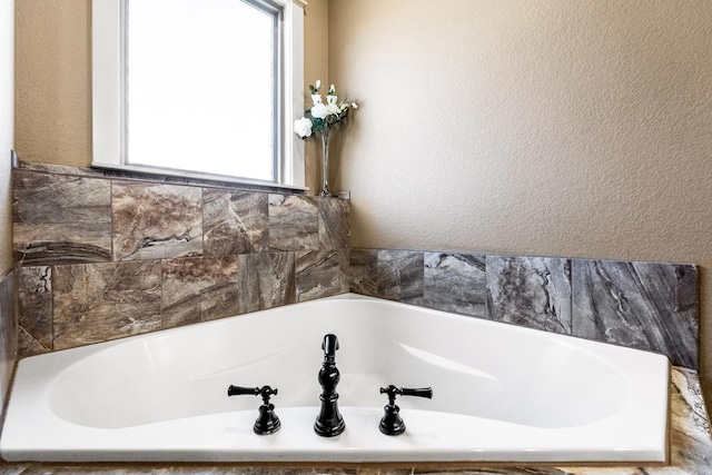 bathroom with a tub to relax in and a wealth of natural light