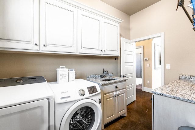 clothes washing area with cabinets, sink, and washing machine and dryer