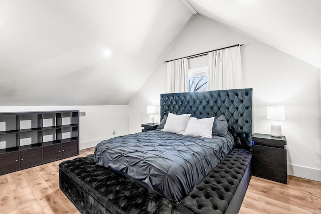 bedroom with lofted ceiling and light wood-type flooring