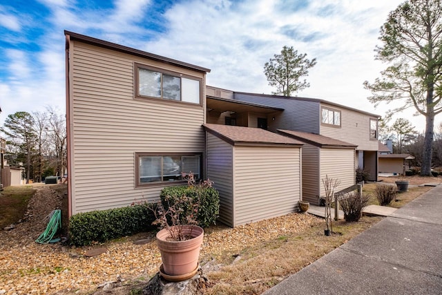 view of property exterior with roof with shingles