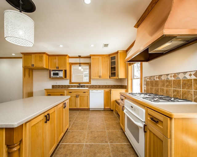 kitchen with white appliances, island exhaust hood, sink, pendant lighting, and backsplash