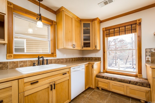 kitchen with hanging light fixtures, white dishwasher, sink, dark tile patterned flooring, and ornamental molding