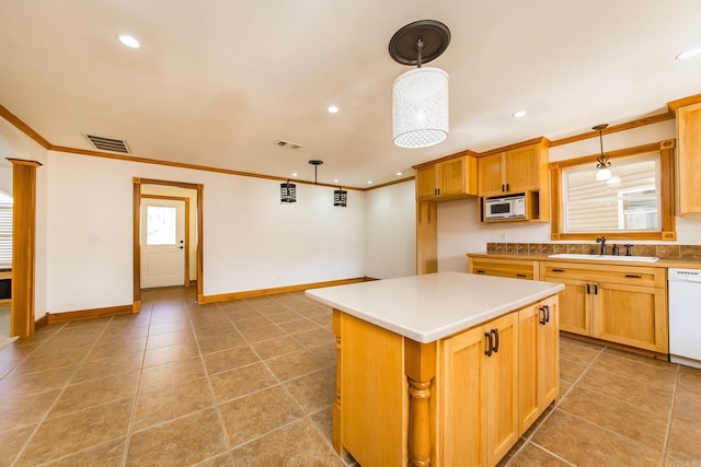 kitchen with pendant lighting, a center island, a healthy amount of sunlight, sink, and built in microwave