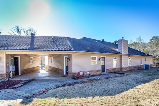 rear view of house featuring central air condition unit and a carport