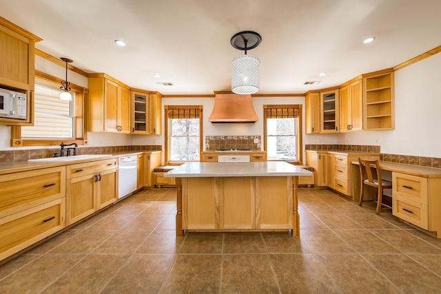 kitchen featuring hanging light fixtures, custom range hood, white appliances, a center island, and ornamental molding