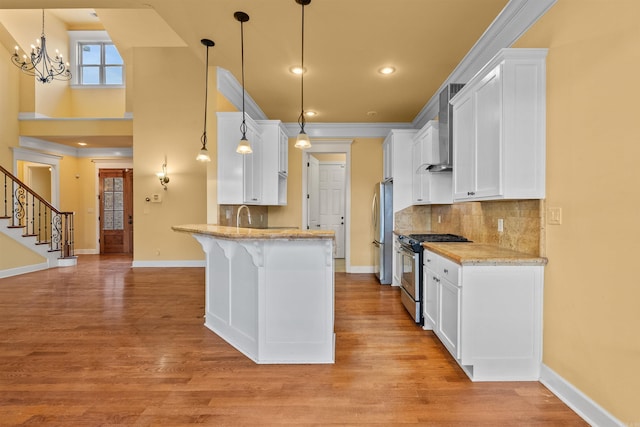 kitchen featuring white cabinets, stainless steel appliances, pendant lighting, and decorative backsplash