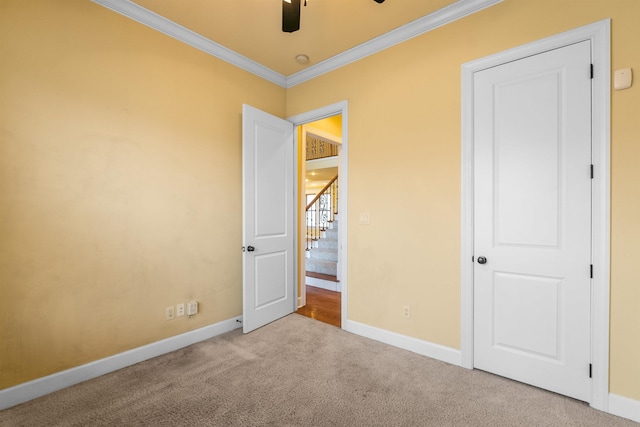 unfurnished bedroom with ceiling fan, ornamental molding, and light carpet