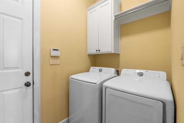 washroom featuring cabinets and washing machine and clothes dryer