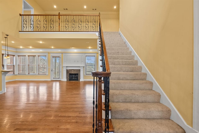 stairs featuring hardwood / wood-style floors and a tiled fireplace